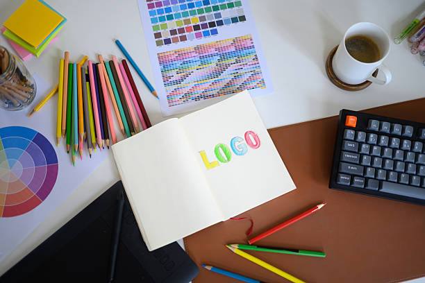 istock Top view of creative workspace with colorful pencils, color palette, and notebook 2239488327
