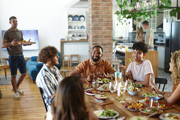 istock Diverse friends enjoying in conversation during a meal at dining table. 2239488860