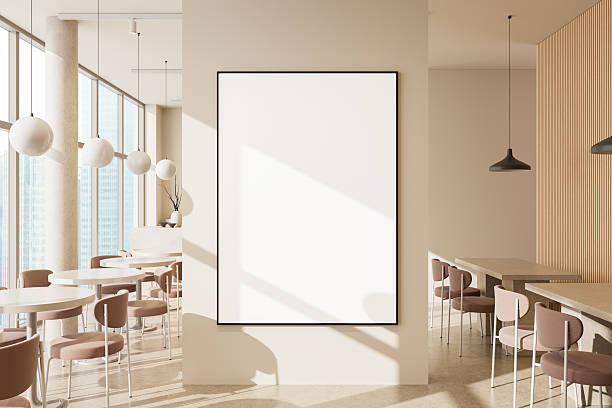 istock Modern cafe interior with sunlight and framed wall poster mockup on beige partition wall in open seating area with minimalist furniture and decor. 3D Rendering 2239490417