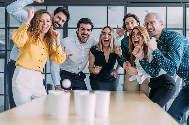 istock Young colleagues playing beer pong in the office. 2239490521