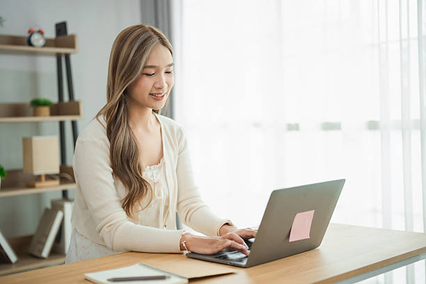 istock Young woman working on laptop in modern office space with natural light, focused on tasks and showcasing productivity and contemporary workspace design 2239491957