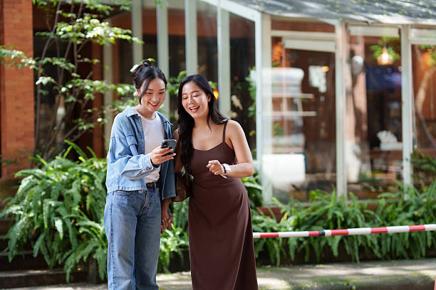 istock Friends sharing smartphone content outdoors, laughing together 2239495261