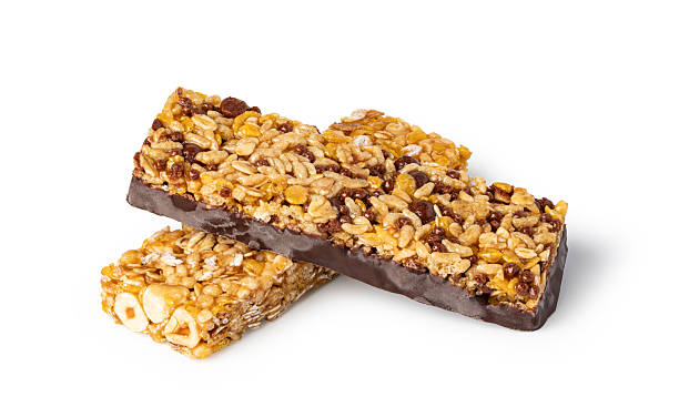 istock Two delicious granola bars with chocolate, hazelnuts and puffed rice resting on white background 2239497358