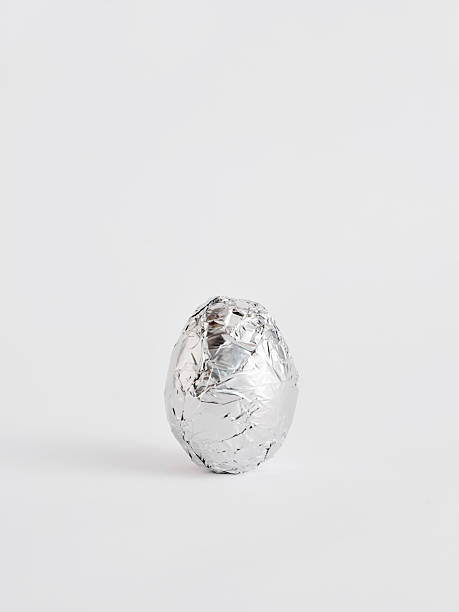 istock Egg wrapped in silver aluminum foil on white background 2239499182
