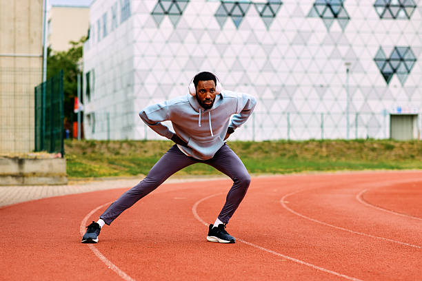 istock Athlete stretching leg muscles on a running track 2239500698