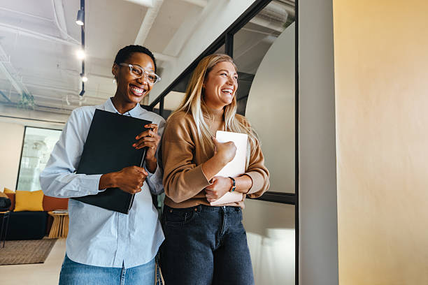 istock Two female colleagues sharing a laugh at work in an office setting 2239502226