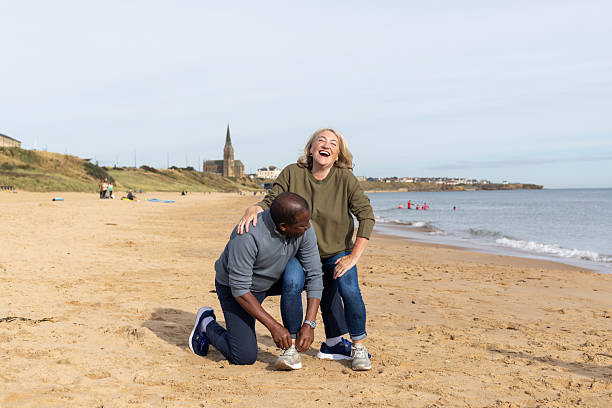 istock Husband Helping to Tie Wife's Shoes 2239506086