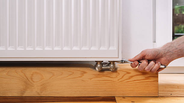 istock Man performs radiator maintenance in a cozy home interior during winter months 2239506792