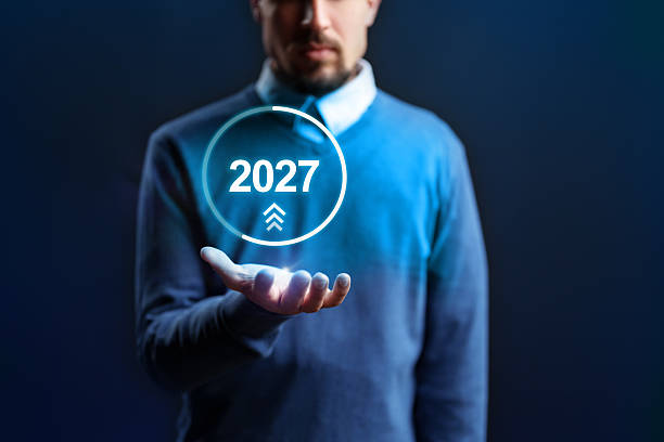 istock Man holding a futuristic display showing the year 2027 in a technology-themed setting 2239508327