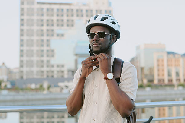 istock Young Adult Black Man Adjusting Helmet While Standing Outdoors near River 2239508470