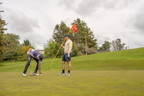 istock Golfers on Green with Flagstick 2239511305