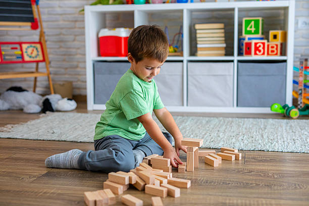 istock Creative Child Constructing with Wooden Toys in Playroom 2239511406
