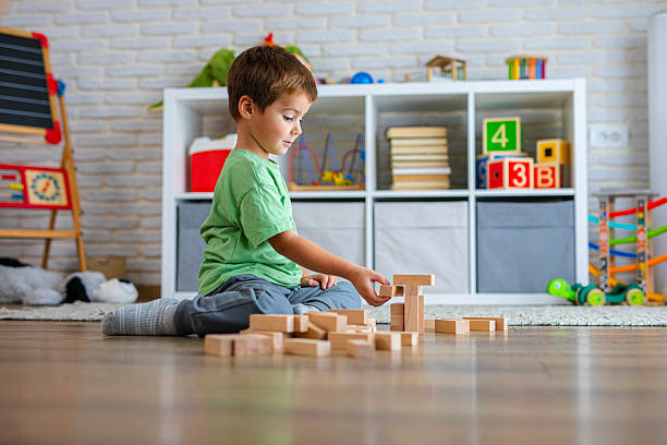 istock Creative Child Constructing with Wooden Toys in Playroom 2239511419