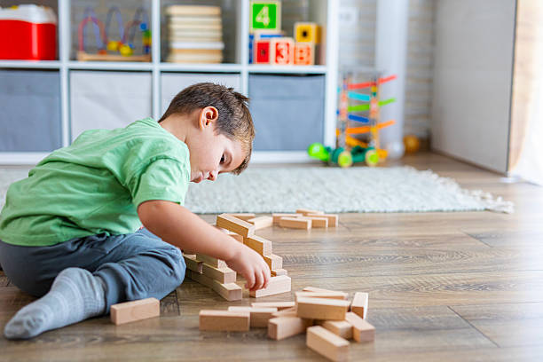 istock Creative Child Constructing with Wooden Toys in Playroom 2239511539