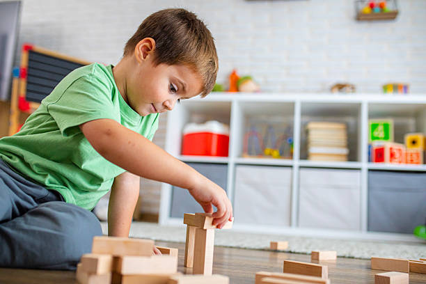 istock Creative Child Constructing with Wooden Toys in Playroom 2239512969