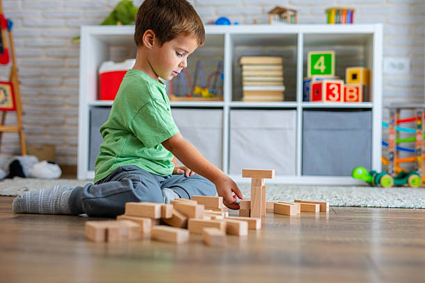 istock Creative Child Constructing with Wooden Toys in Playroom 2239513320