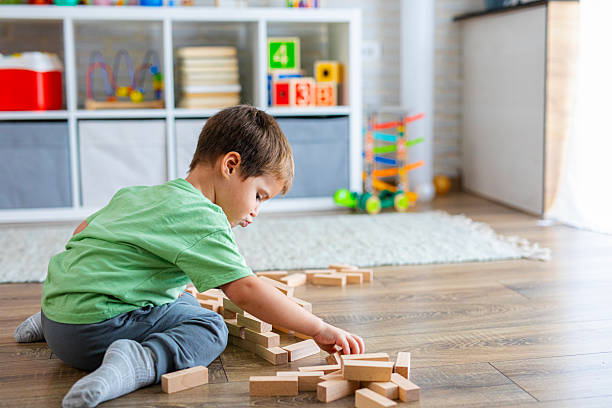 istock Creative Child Constructing with Wooden Toys in Playroom 2239513395