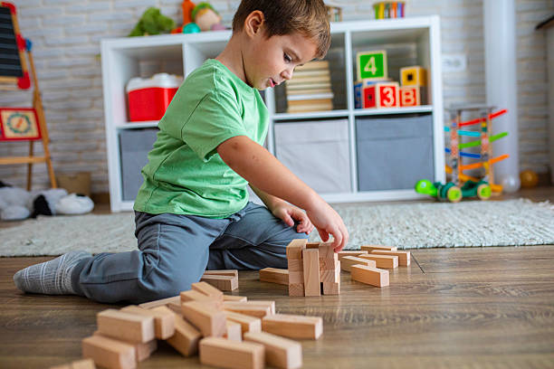 istock Creative Child Constructing with Wooden Toys in Playroom 2239513685