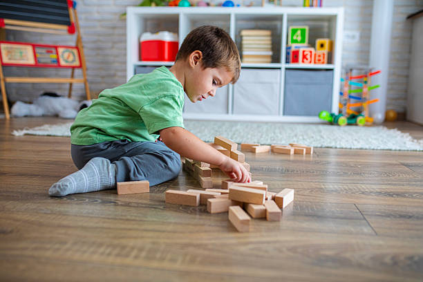 istock Creative Child Constructing with Wooden Toys in Playroom 2239513748