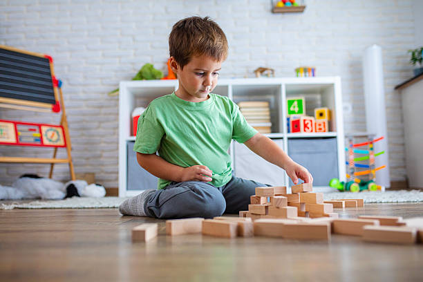 istock Creative Child Constructing with Wooden Toys in Playroom 2239513770