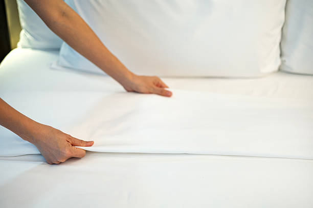 istock Making bed with clean white sheets in cozy bedroom 2239513813