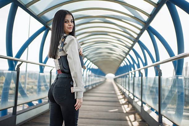 istock Young woman looking back in modern pedestrian bridge 2239514522