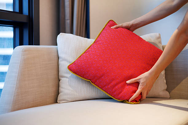 istock Arranging red cushion on modern beige sofa 2239514716