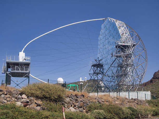 MAGIC Telescope at Roque de los Muchachos Observatory - The MAGIC gamma-ray telescope, a massive reflective dish and metal structure, dominates the landscape at the Roque de los Muchachos Observatory.