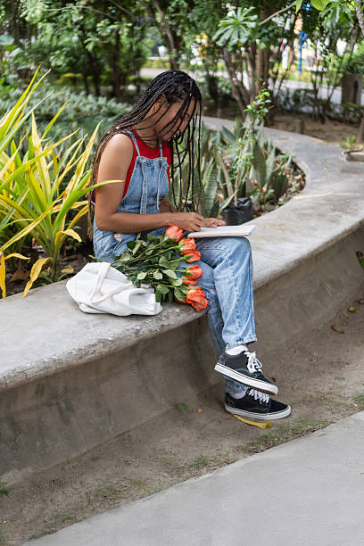 istock Woman writing in journal with roses in park 2239516541