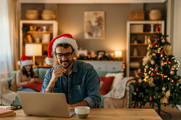 istock Man wearing santa hat working on laptop during christmas holidays 2239517687