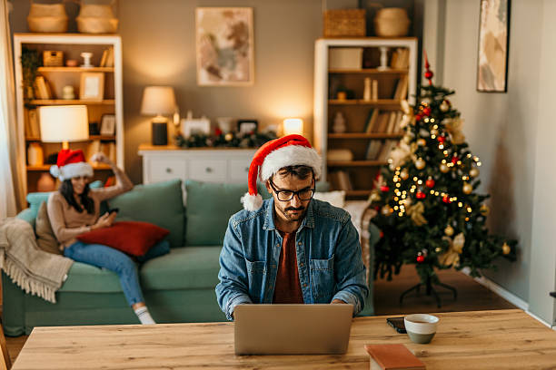 istock Man wearing santa hat working from home during christmas 2239517783