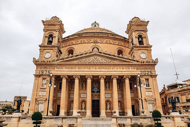 istock Mosta, Malta - April 14, 2025: The Mosta Rotunda, also known as the Mosta Dome, featuring a grand neoclassical facade with Corinthian columns, statues, and twin bell towers 2239518018