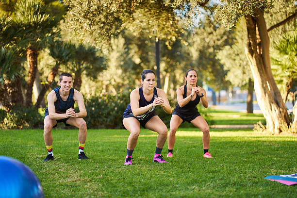 istock Group of people doing squats outdoors in park 2239519010