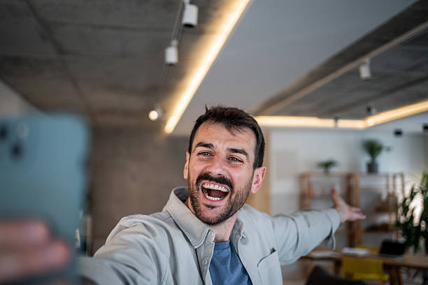 istock Happy man vlogging and taking selfie with smartphone in office 2239522724