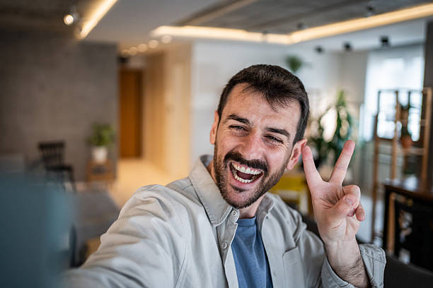 istock Happy man taking a selfie making peace sign 2239522740