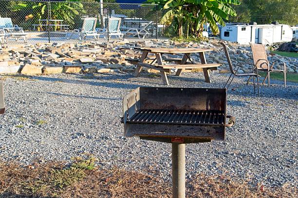 An empty barbecue grill stands unused in a public park on a sunny autumn afternoon waiting for the summer activity.