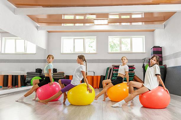 istock Girls practicing poses on colorful stability balls 2239525257