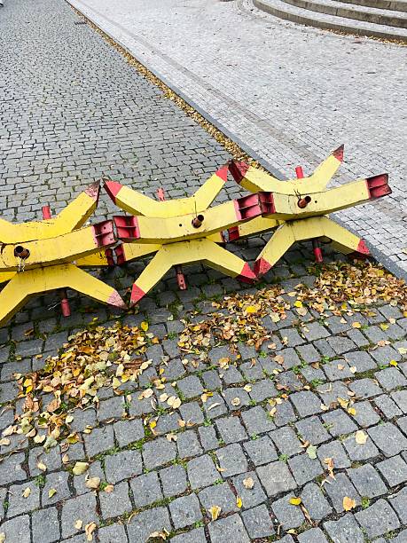Yellow star shaped barriers positioned in a strategic formation, associated with military defense or restricted zone security. Fall yellow leaves