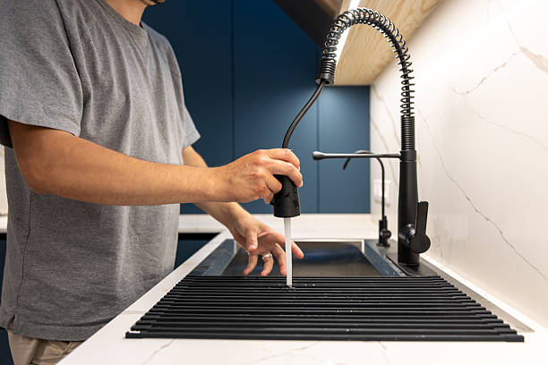 istock Man cleaning kitchen rack with pull out faucet sprayer. Rinsing the drainer. 2239528534