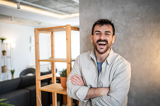 istock Man laughing with arms crossed, standing indoors 2239531873