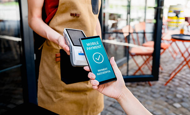 istock Customer making mobile payment with phone at cafe 2239533990