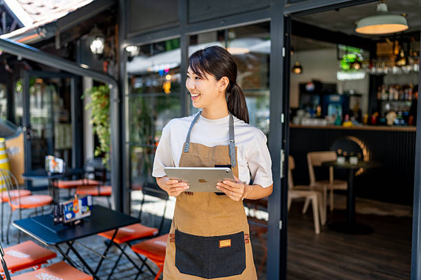 istock Smiling cafe owner using tablet for small business 2239535079
