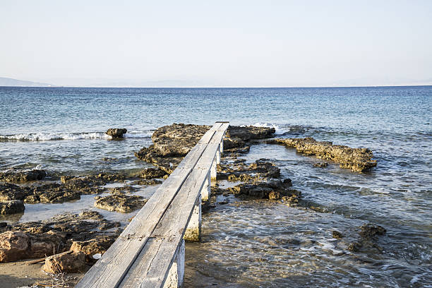 a wooden path leading into the Mediterranean Sea