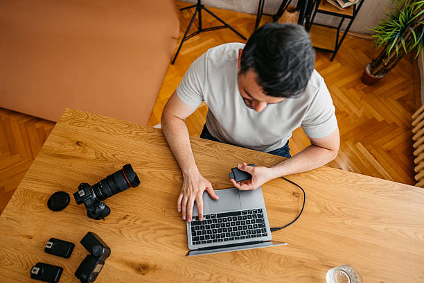 istock Male Photographer Transferring Data On The Laptop In The Studio 2239539614
