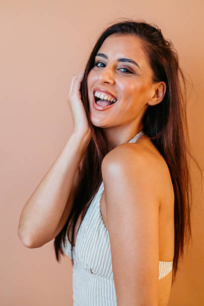 istock Young Woman Posing Against A Brown Background In The Studio 2239540413