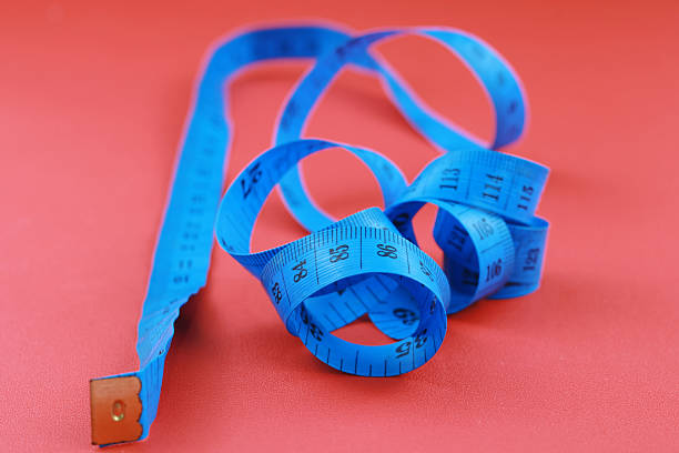 istock Blue measuring tape isolated on red background. 2239541335