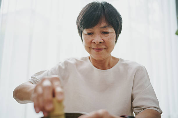 Mature woman making matcha tea.