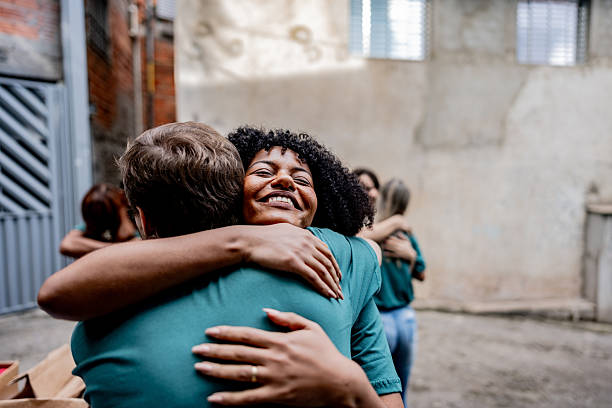 Volunteers embracing during donation event outdoors