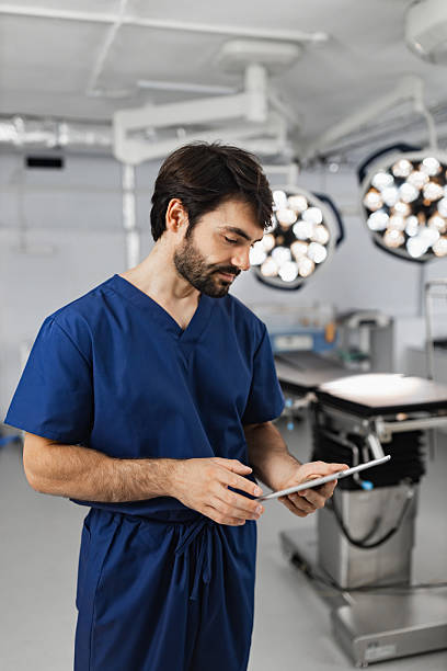 istock Surgeon Reviews Tablet in Operating Room 2239543175
