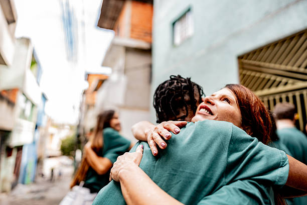 istock Volunteers embracing during donation event outdoors 2239543799